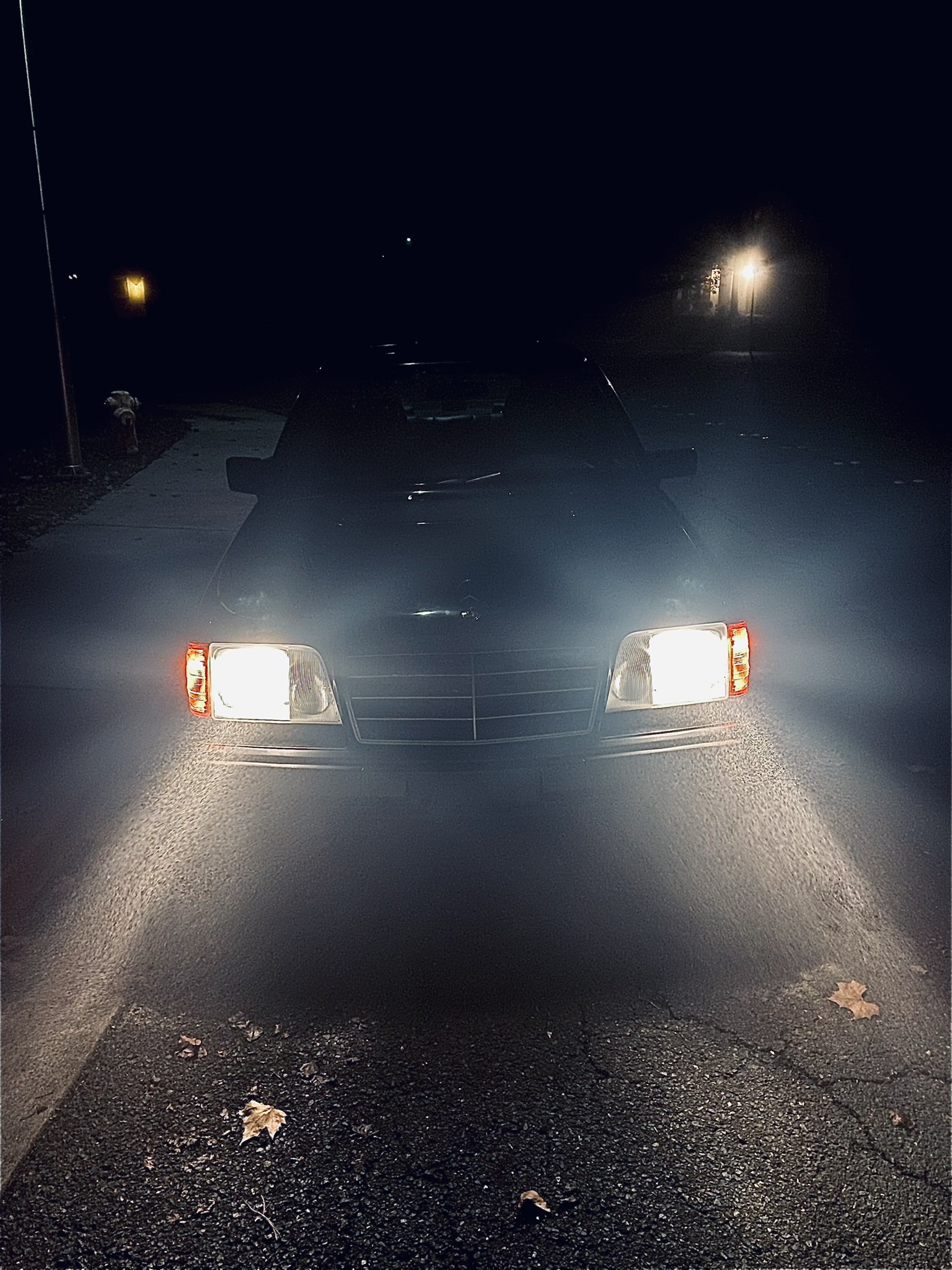 Headlights approaching on a dark road at night.
