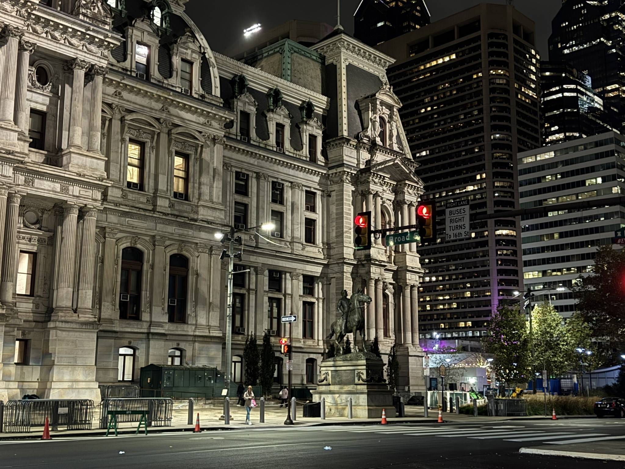 Historic stone building lit at night in a dense urban setting.